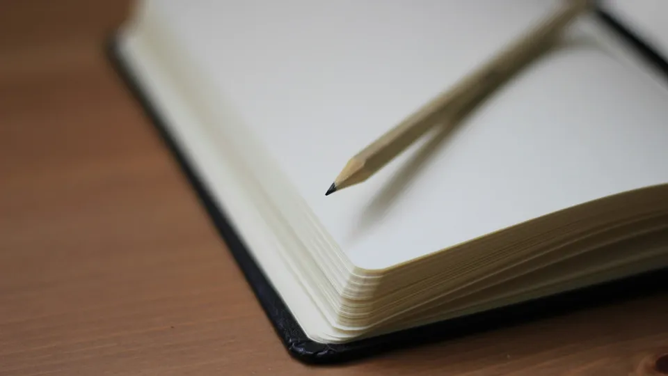 crayon poser sur un carnet aux pages blanches