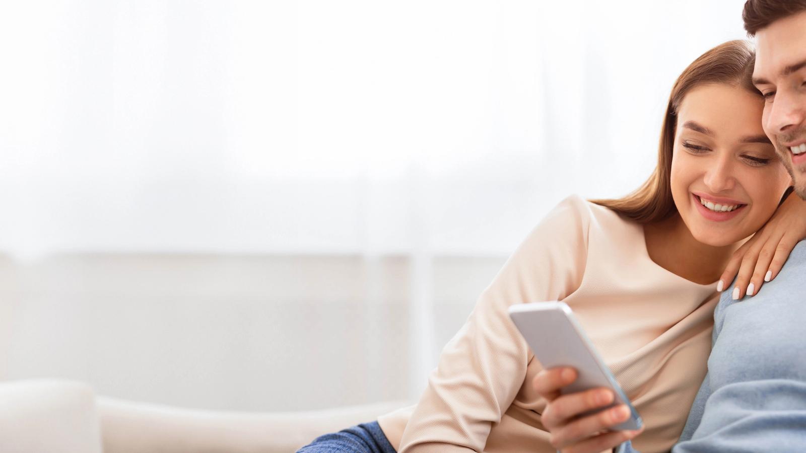 Couple checking their phone together at home