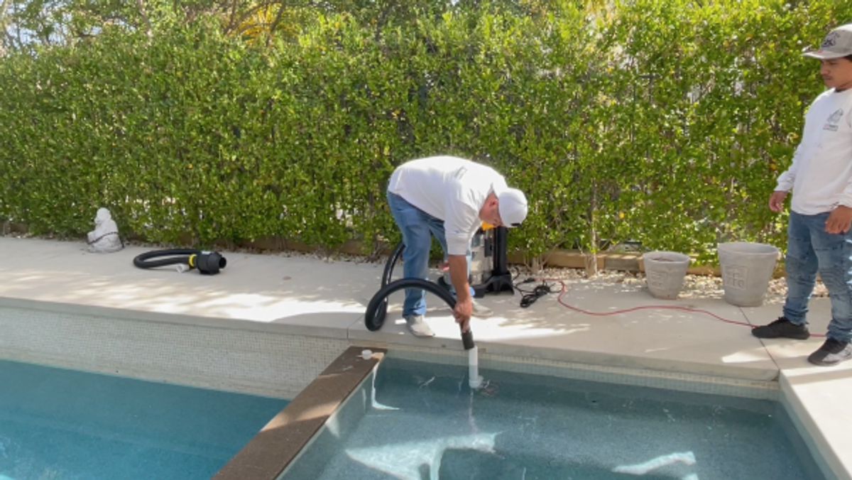 Blower/vacuum purging water out of the pool return line