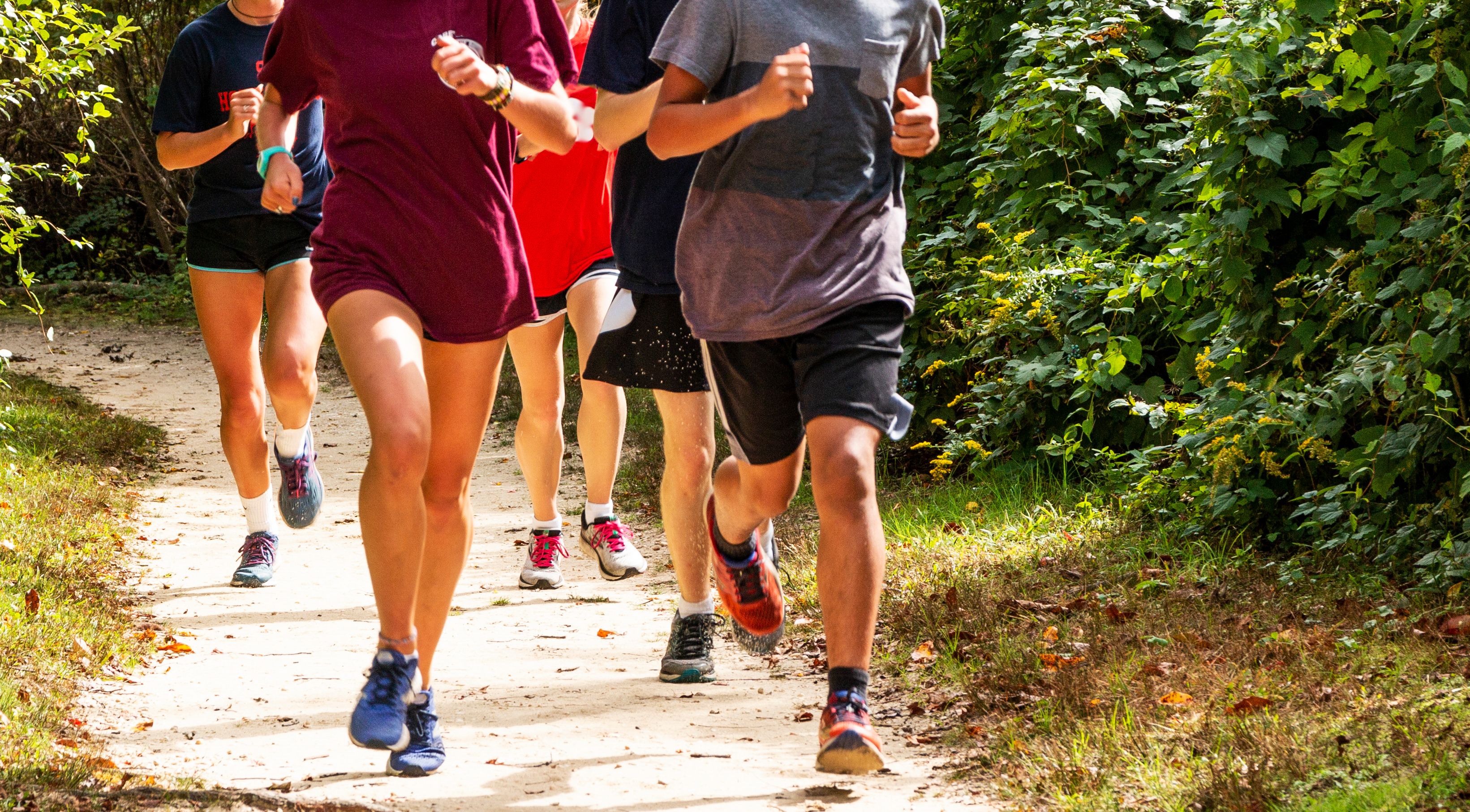 A group of people running together on a trail