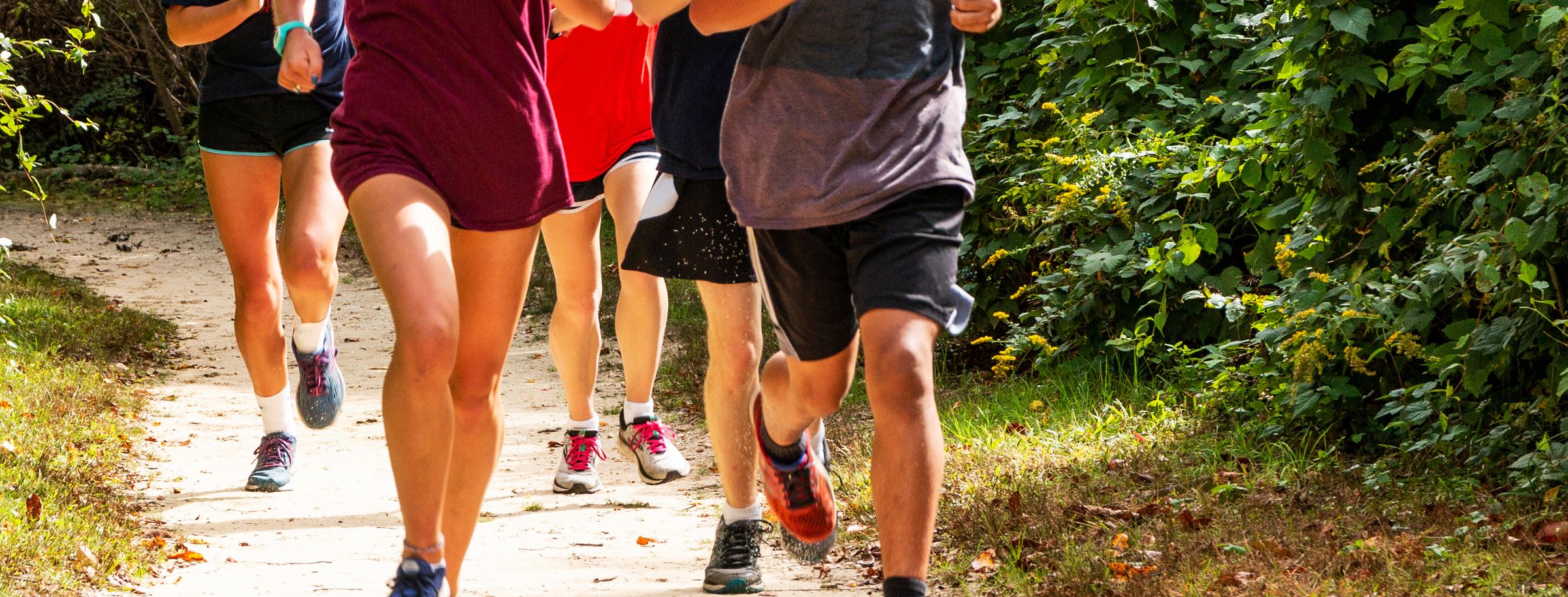 A group of people running together on a trail