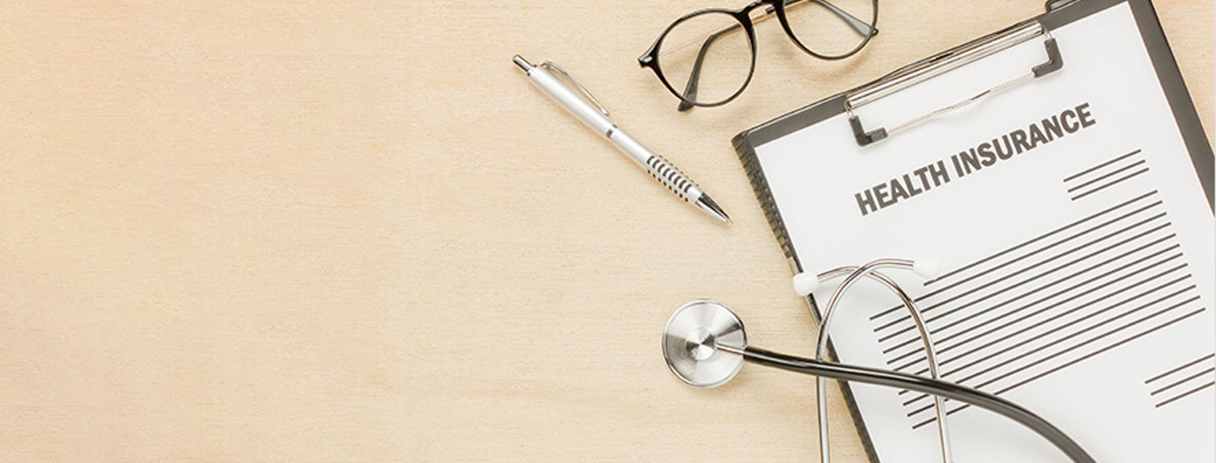 A health insurance application form next to medical items