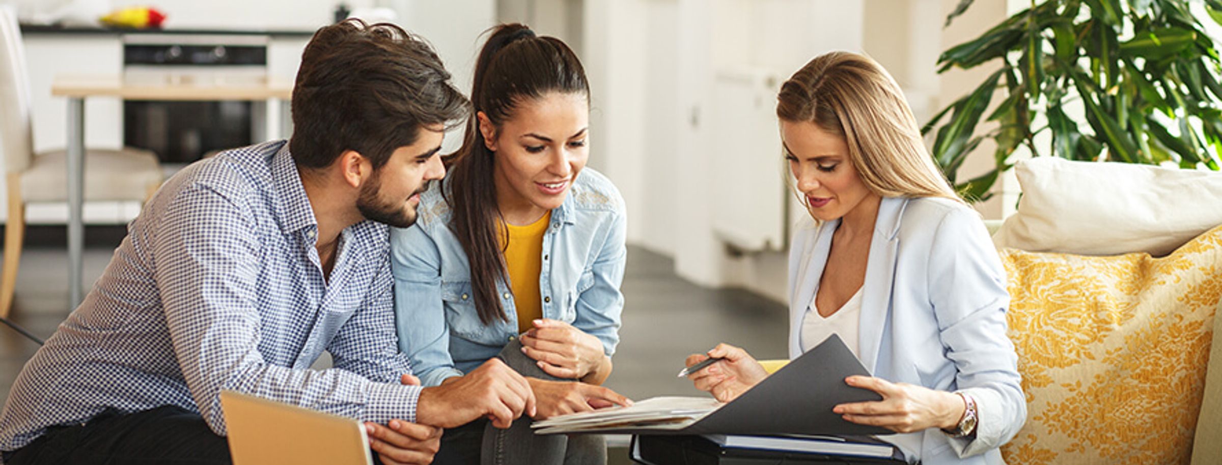 A woman explaining health insurance excess to a couple