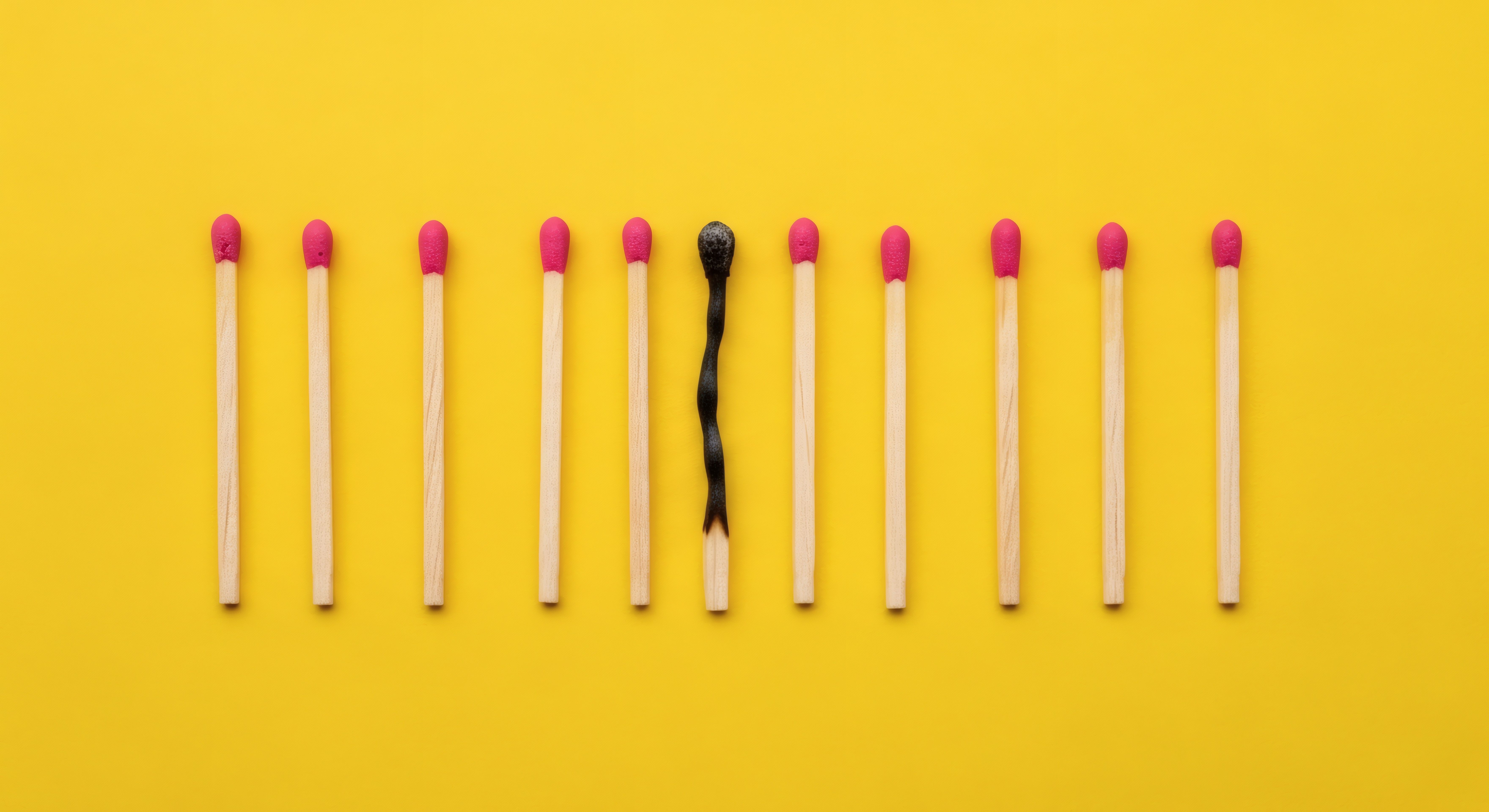 A burnt out match among unlit matches