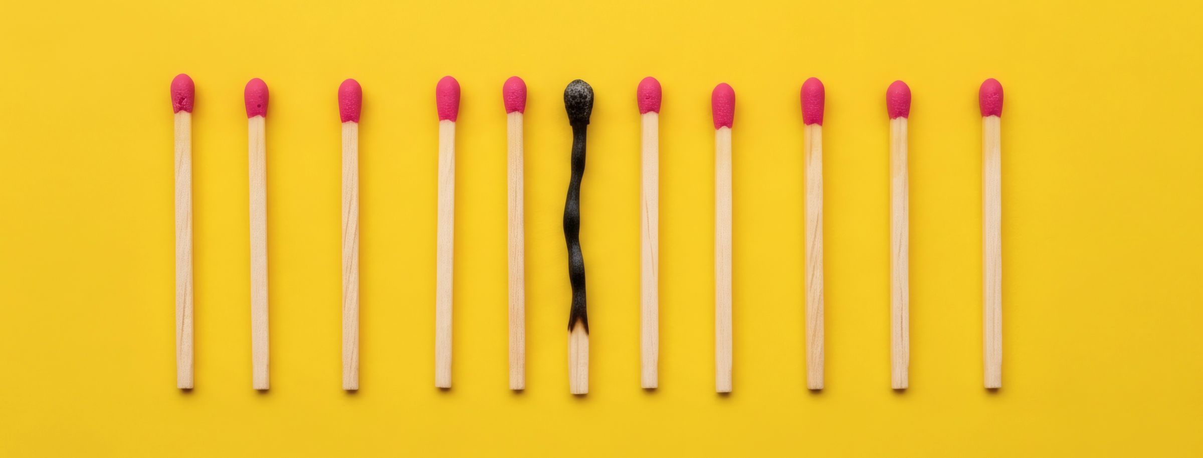 A burnt out match among unlit matches