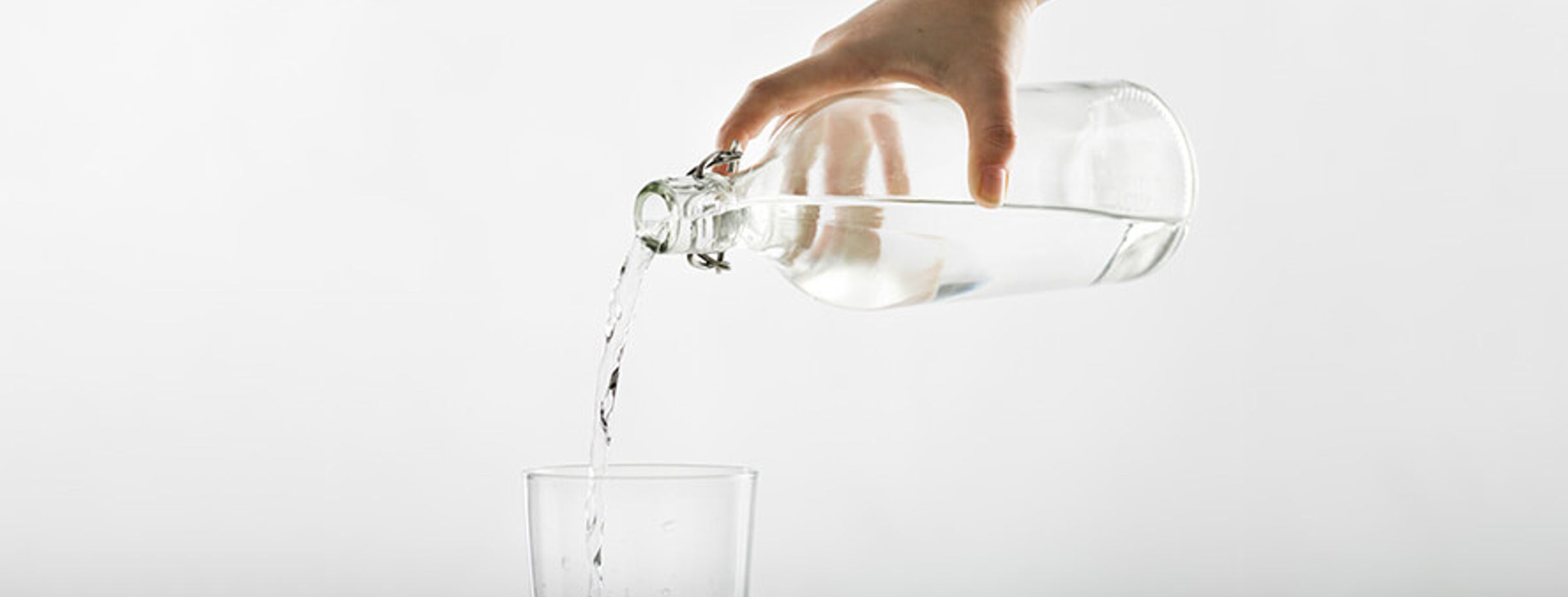 Water being poured from a clear bottle into a glass