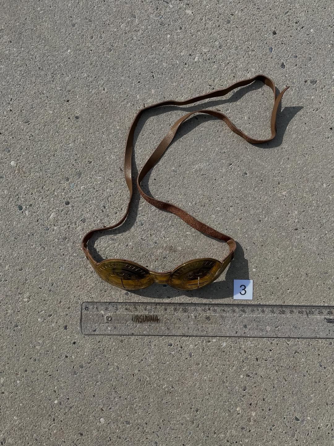 Goggles with full leather strap laid out