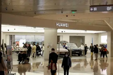 Pohled na Huawei obchod v nákupním centru s několika lidmi, kteří se procházejí kolem.