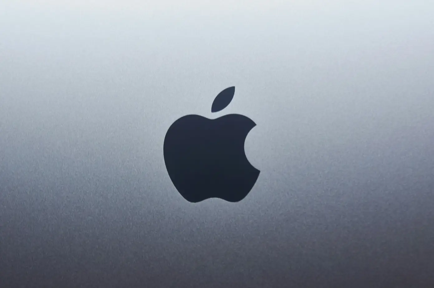 Černé logo Apple na stříbrném pozadí