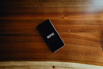 Černý telefon na dřevěném stole s nápisem "INSPIRE"