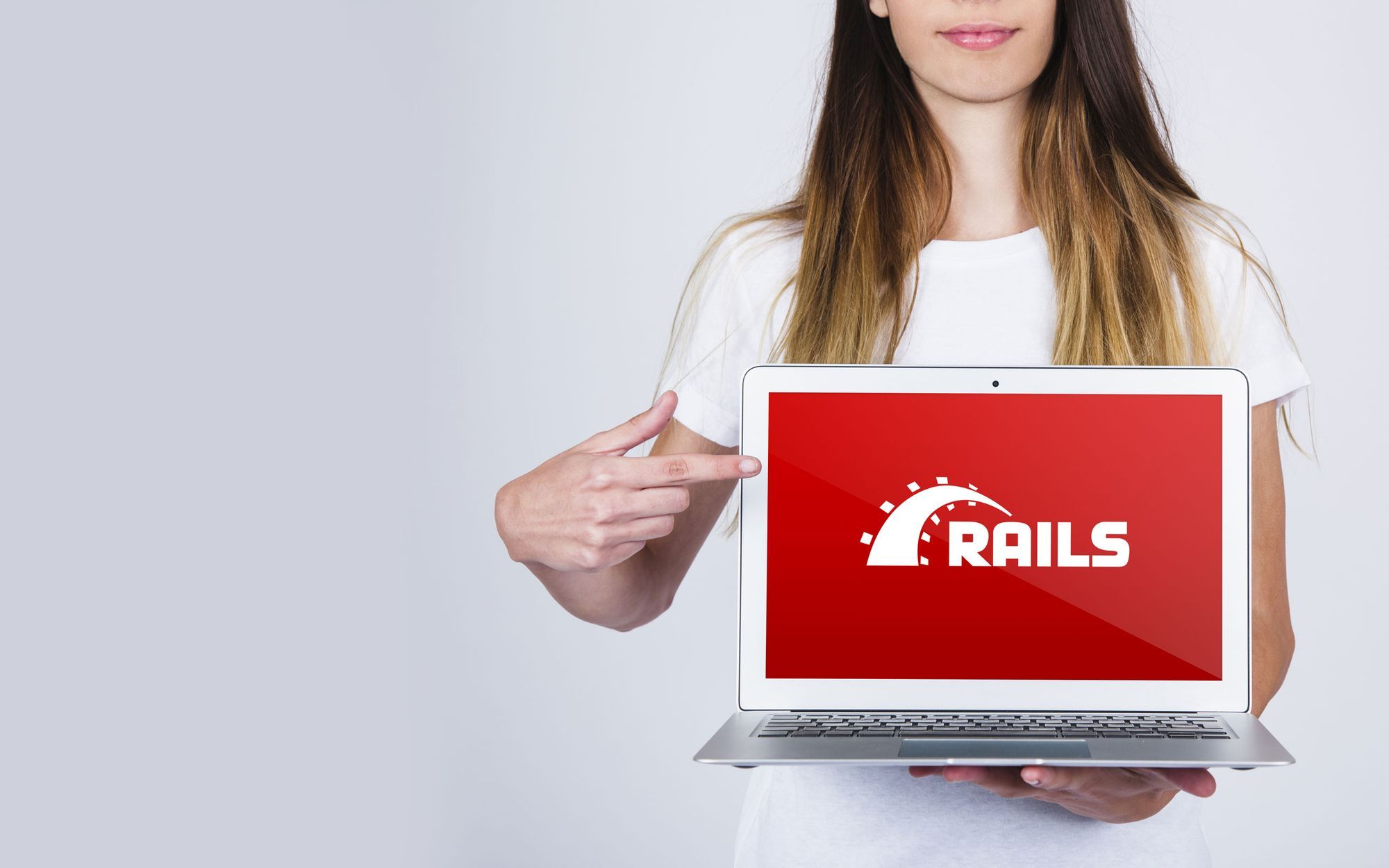 Two woman see the laptop screen whit the Rails Logo