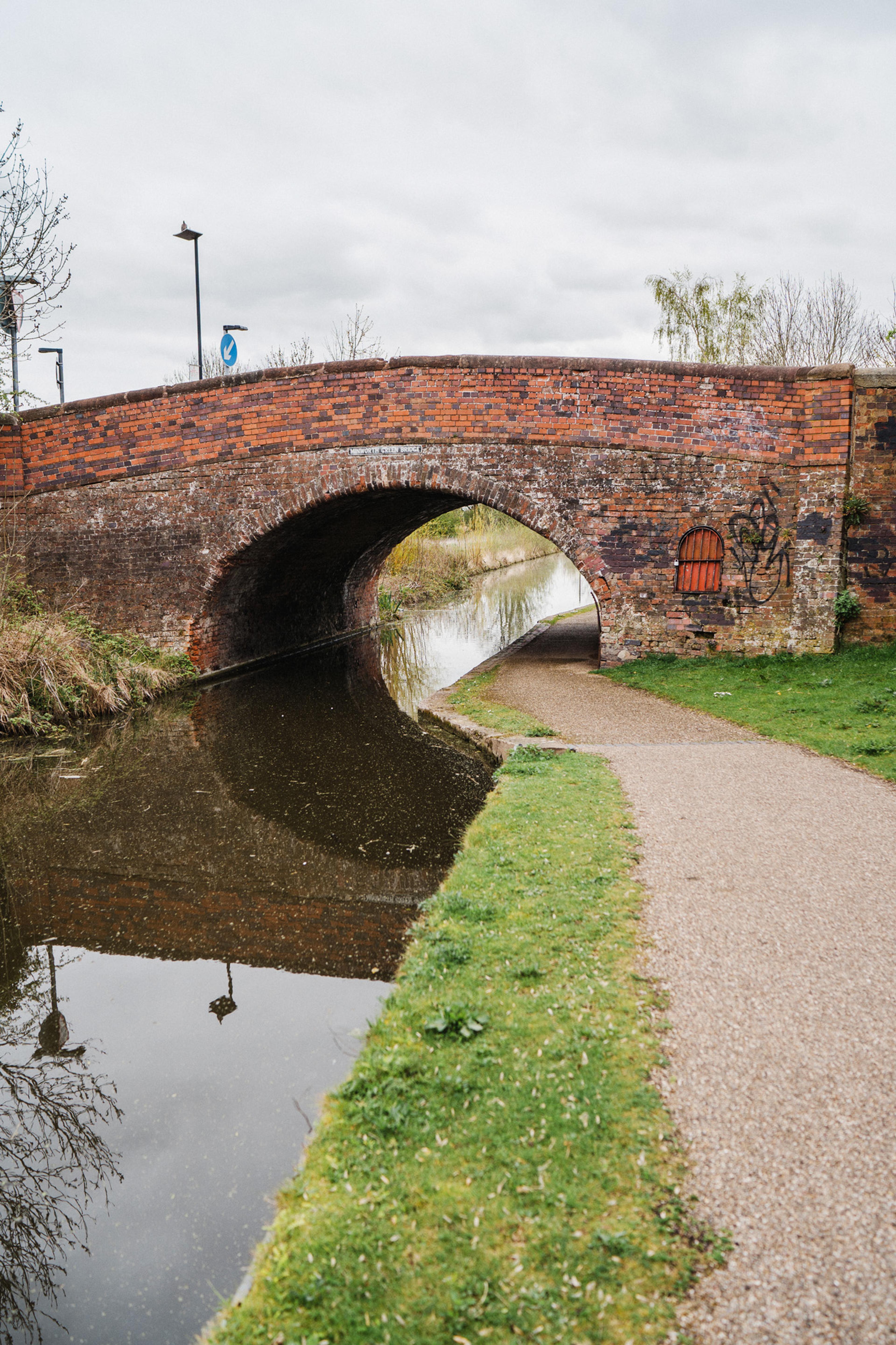 A canal towpath leading under a bridge
