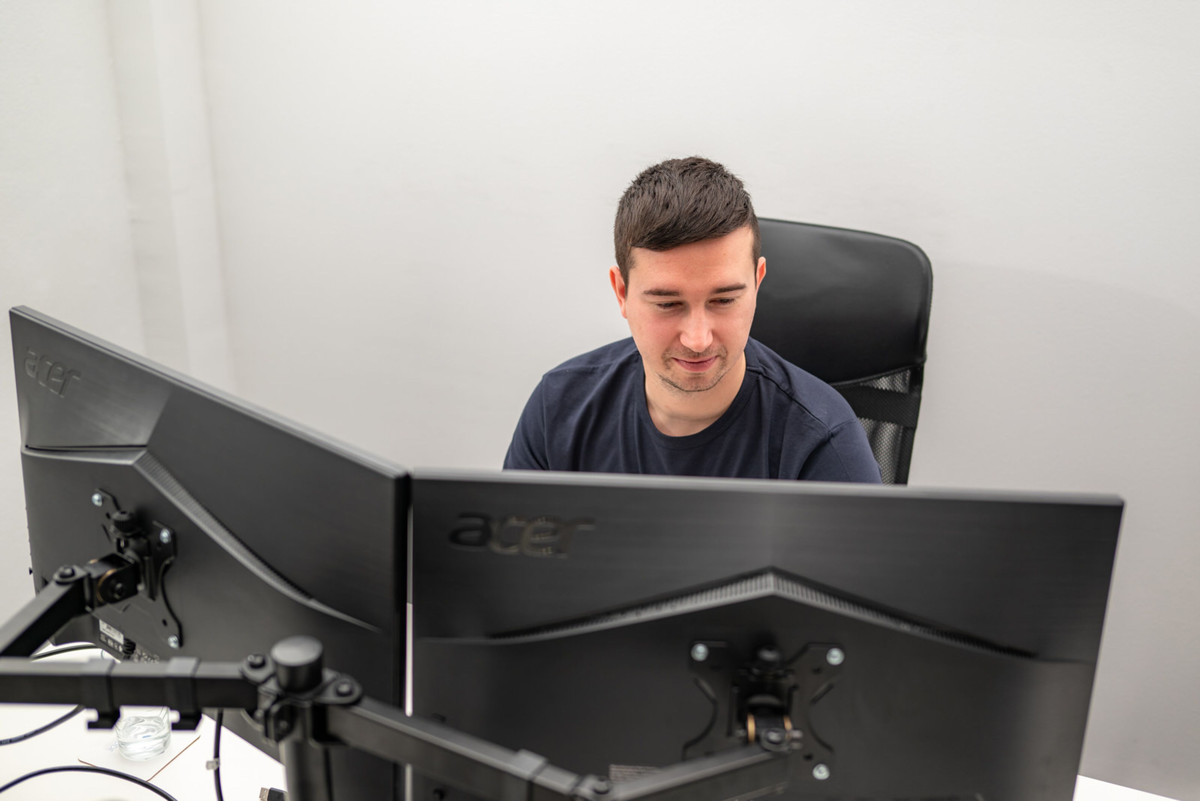 Developer working behind two monitors in an office