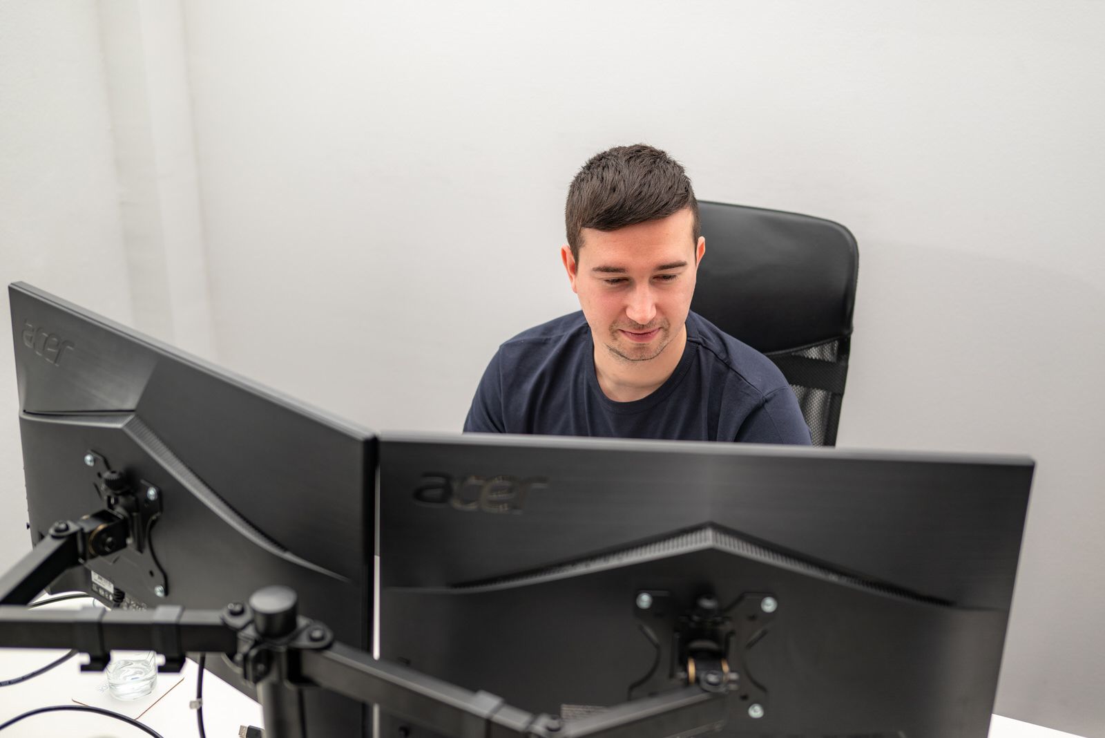 Developer working behind two monitors in an office