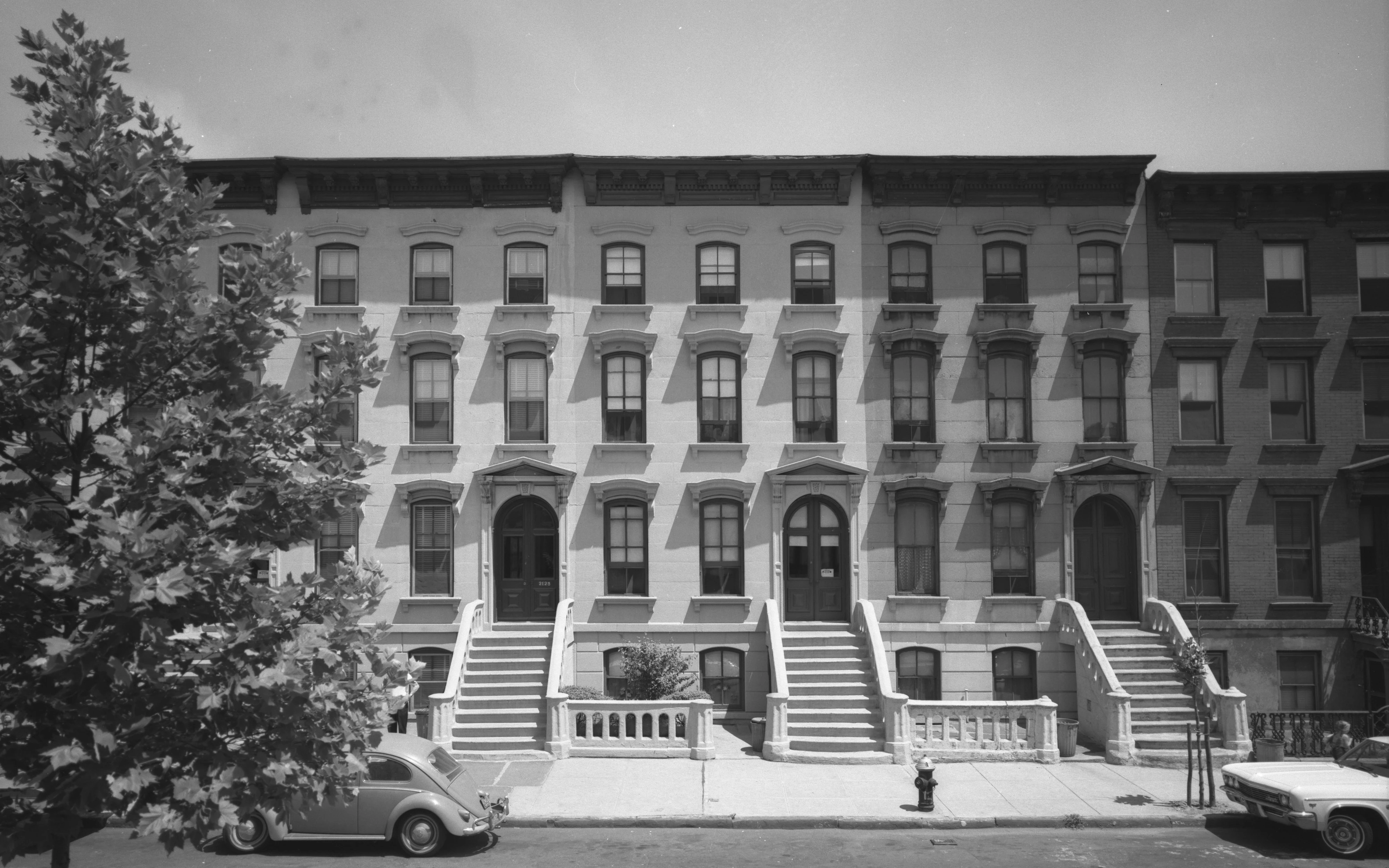A black and white photograph of New York City rowhouses.