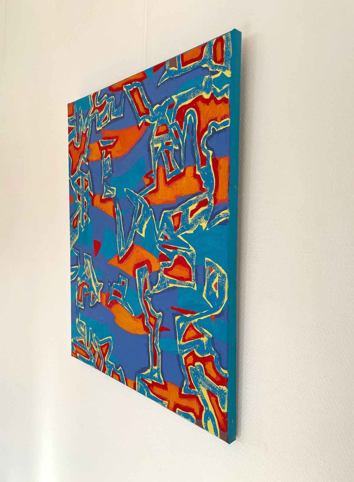abstract oil painting with blue and red tones on the wall, side view