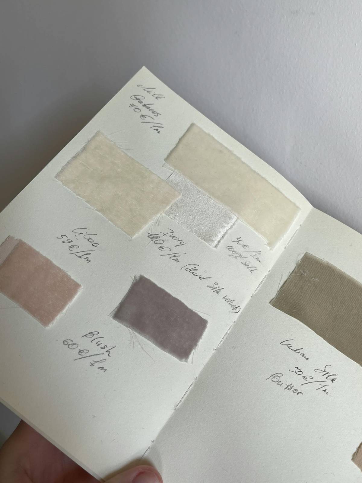 An organized fabric sample book showing labeled textile swatches and structured material options.