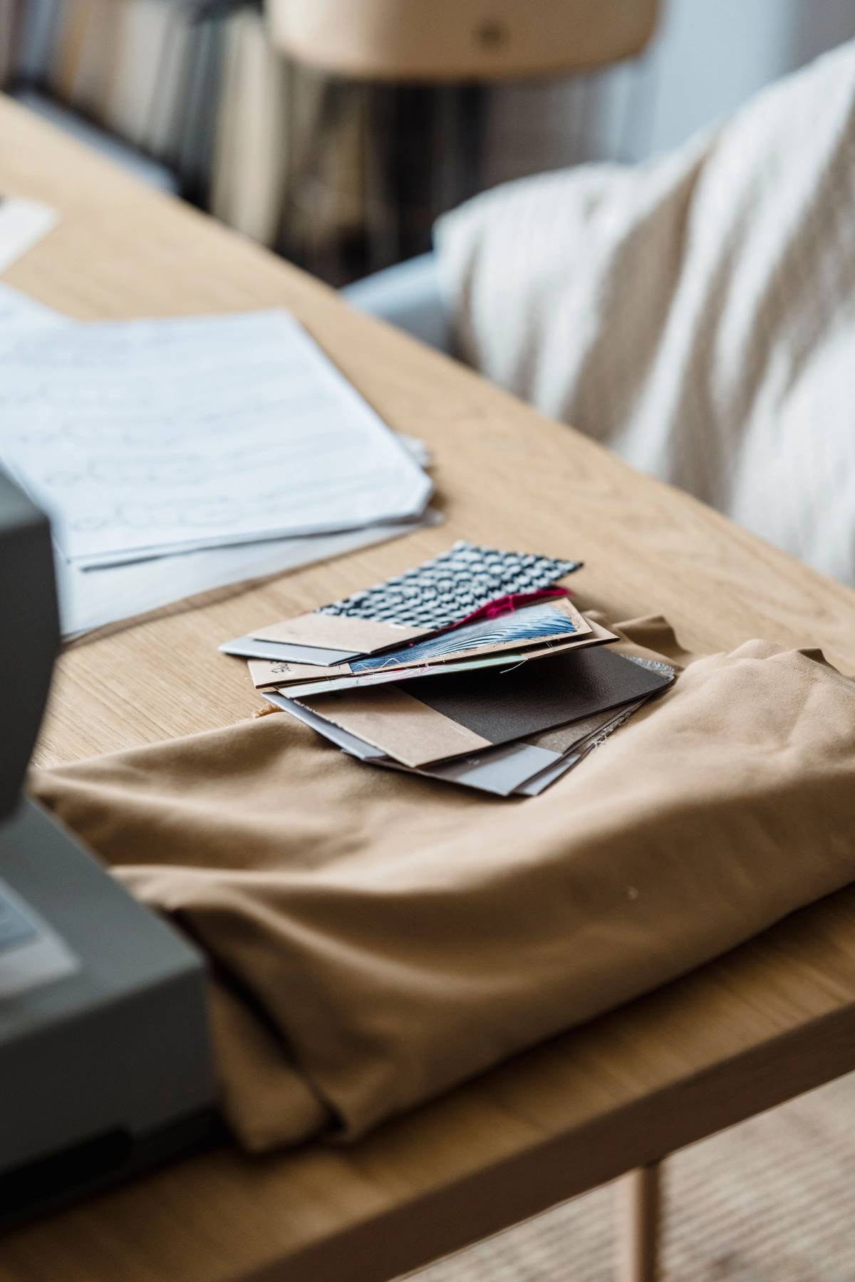 Fabric sample cards and paper records arranged on a textile design worktable