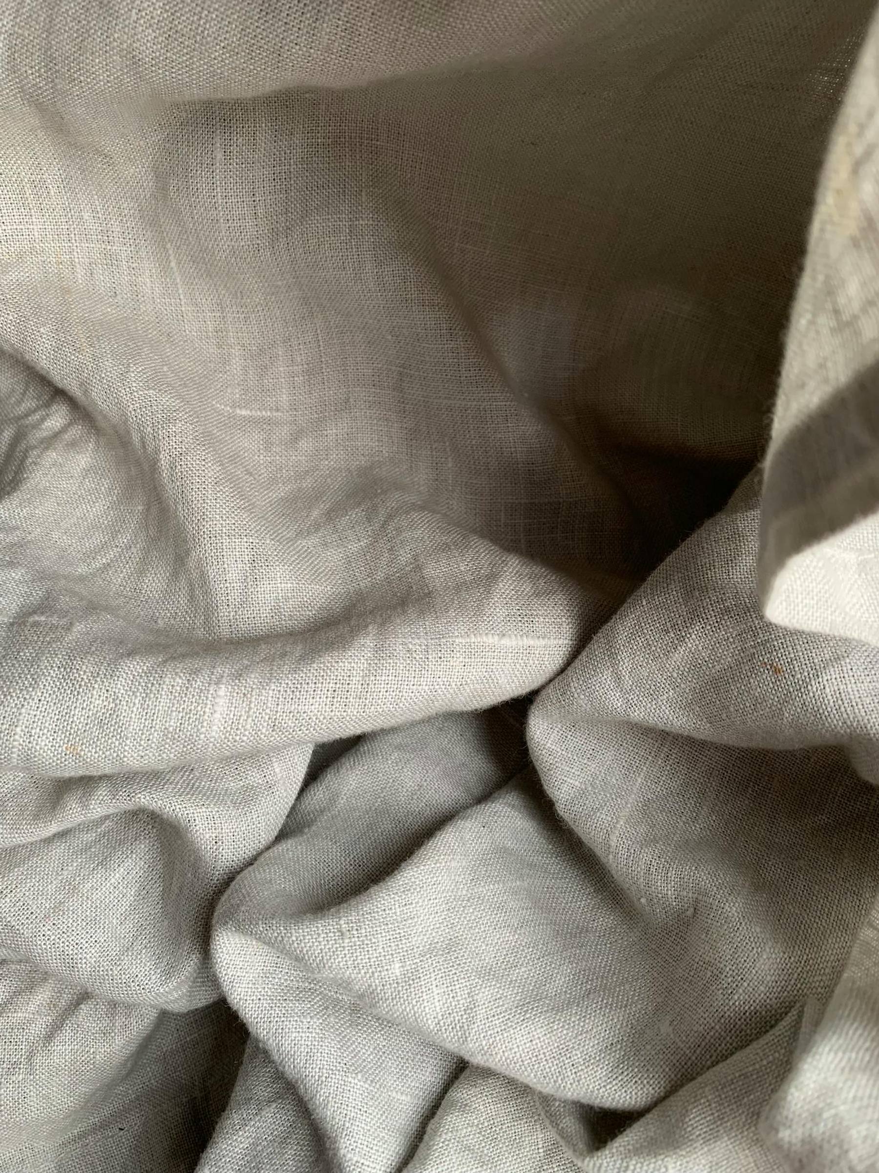 Natural linen fabric folds in warm neutral light.