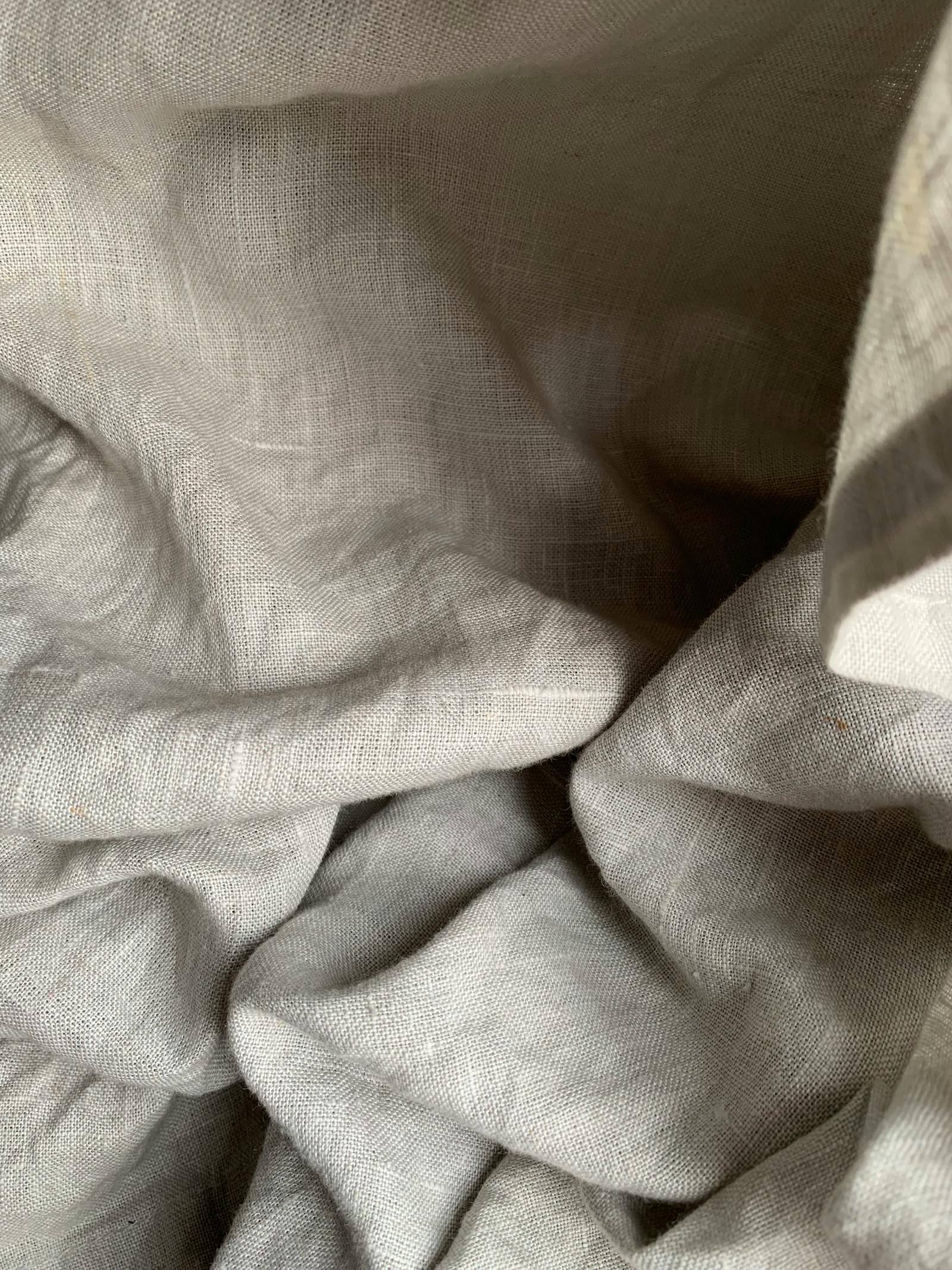 Natural linen fabric folds in warm neutral light.