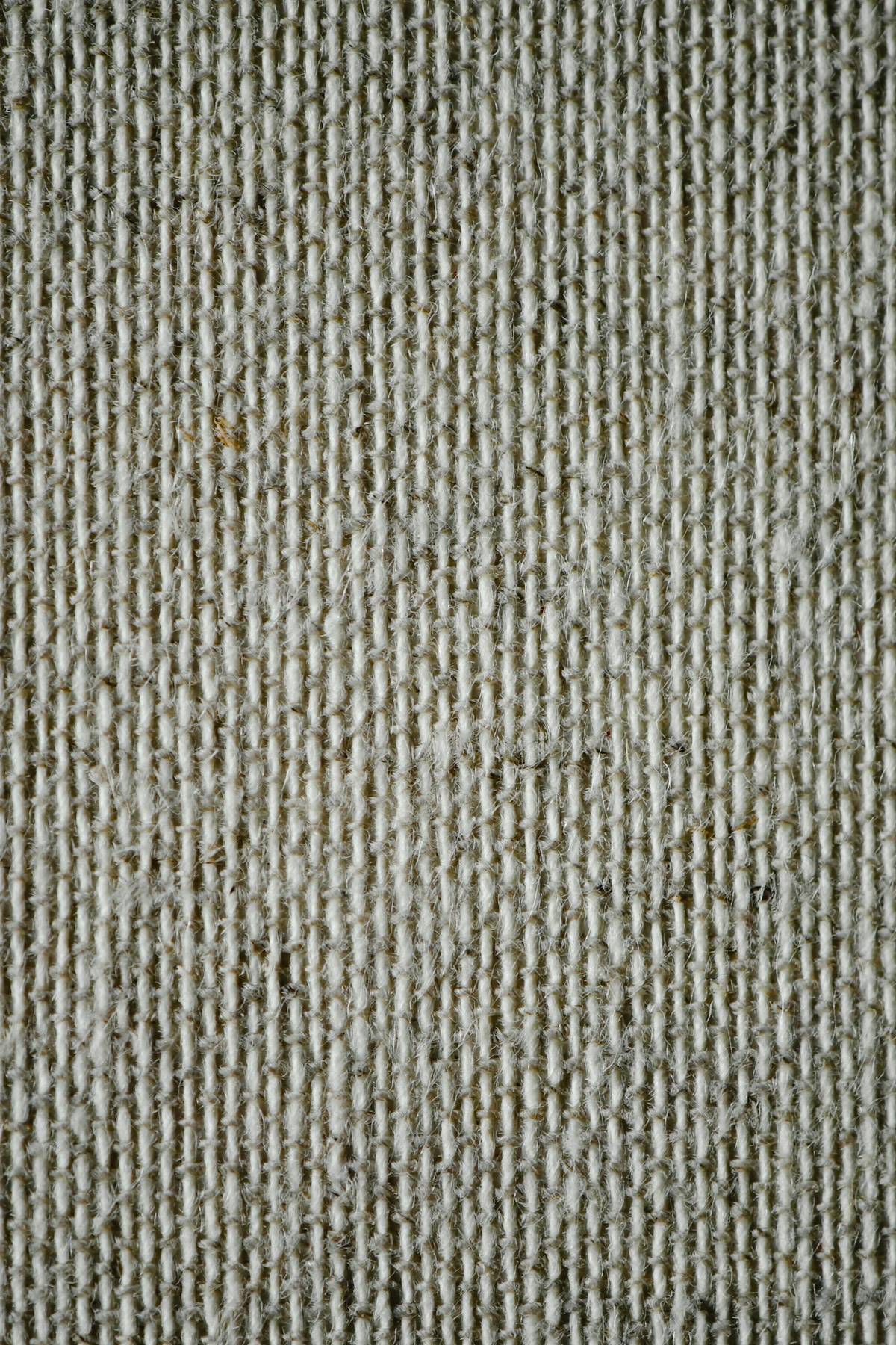 Close-up of woven neutral-toned fabric highlighting texture and lower-impact material choices.