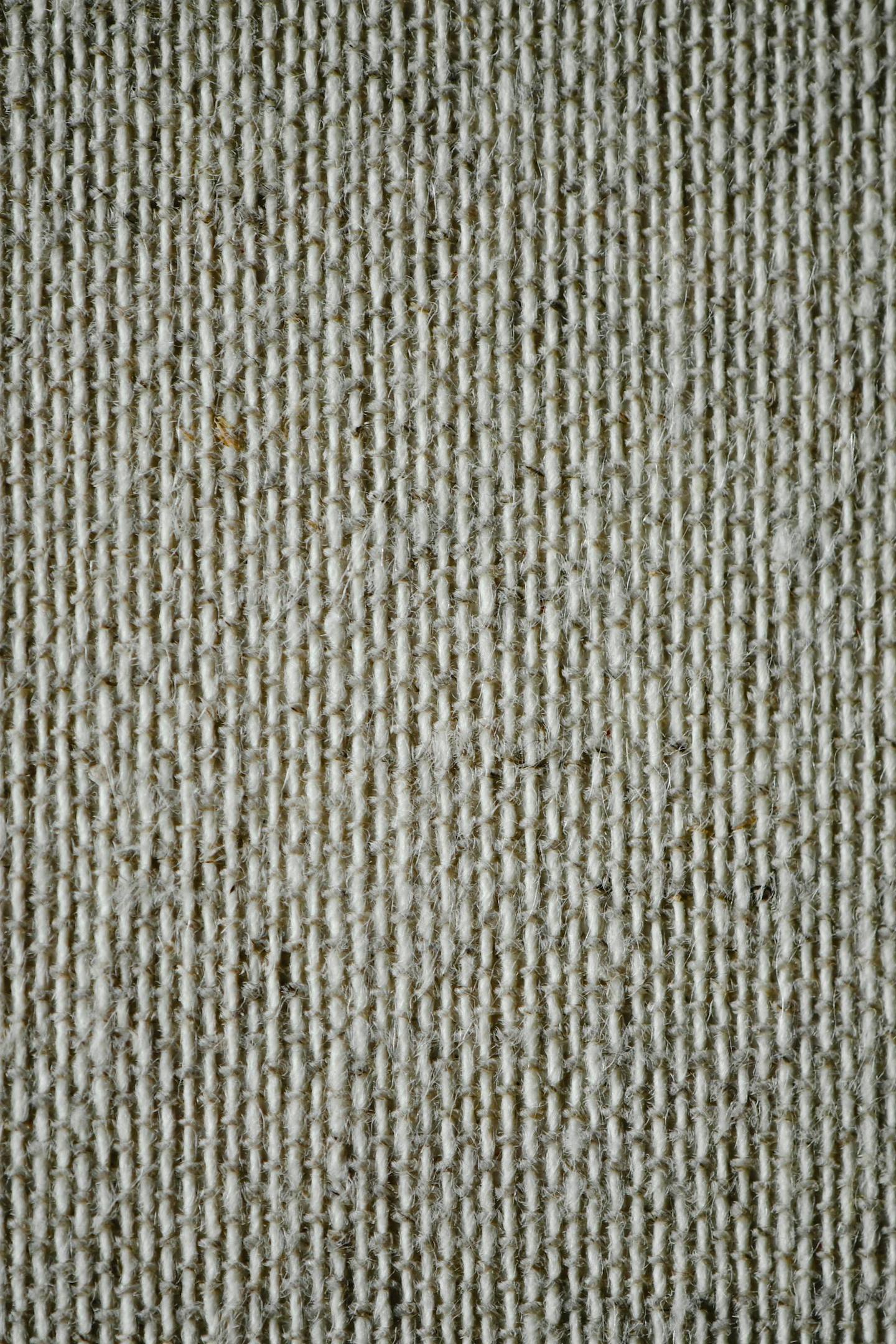 Close-up of woven neutral-toned fabric highlighting texture and lower-impact material choices.