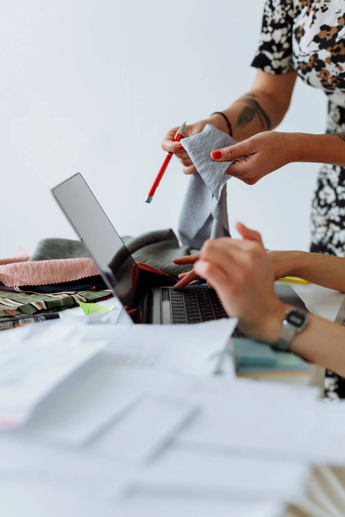 Fashion consultants discussing fabric samples and sourcing options with a client