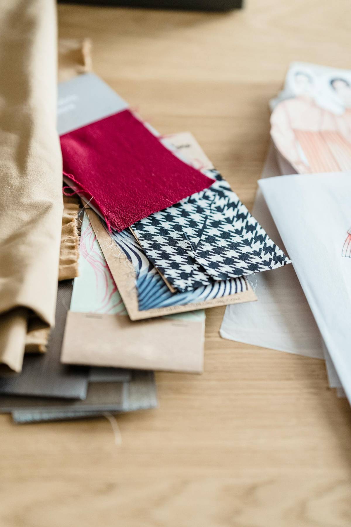 Textile samples and paper sketches arranged on a worktable to support material decisions.