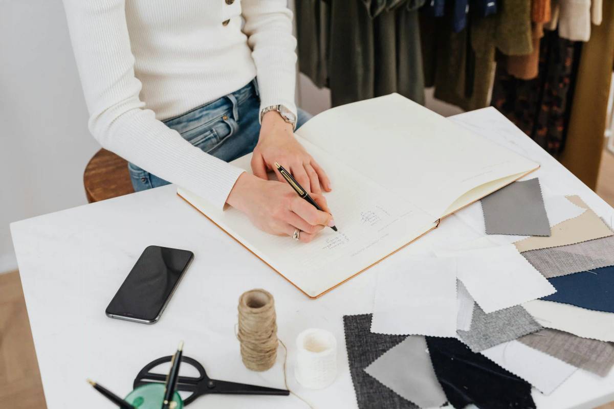 Fashion designer planning a sourcing roadmap with fabric samples and sketches