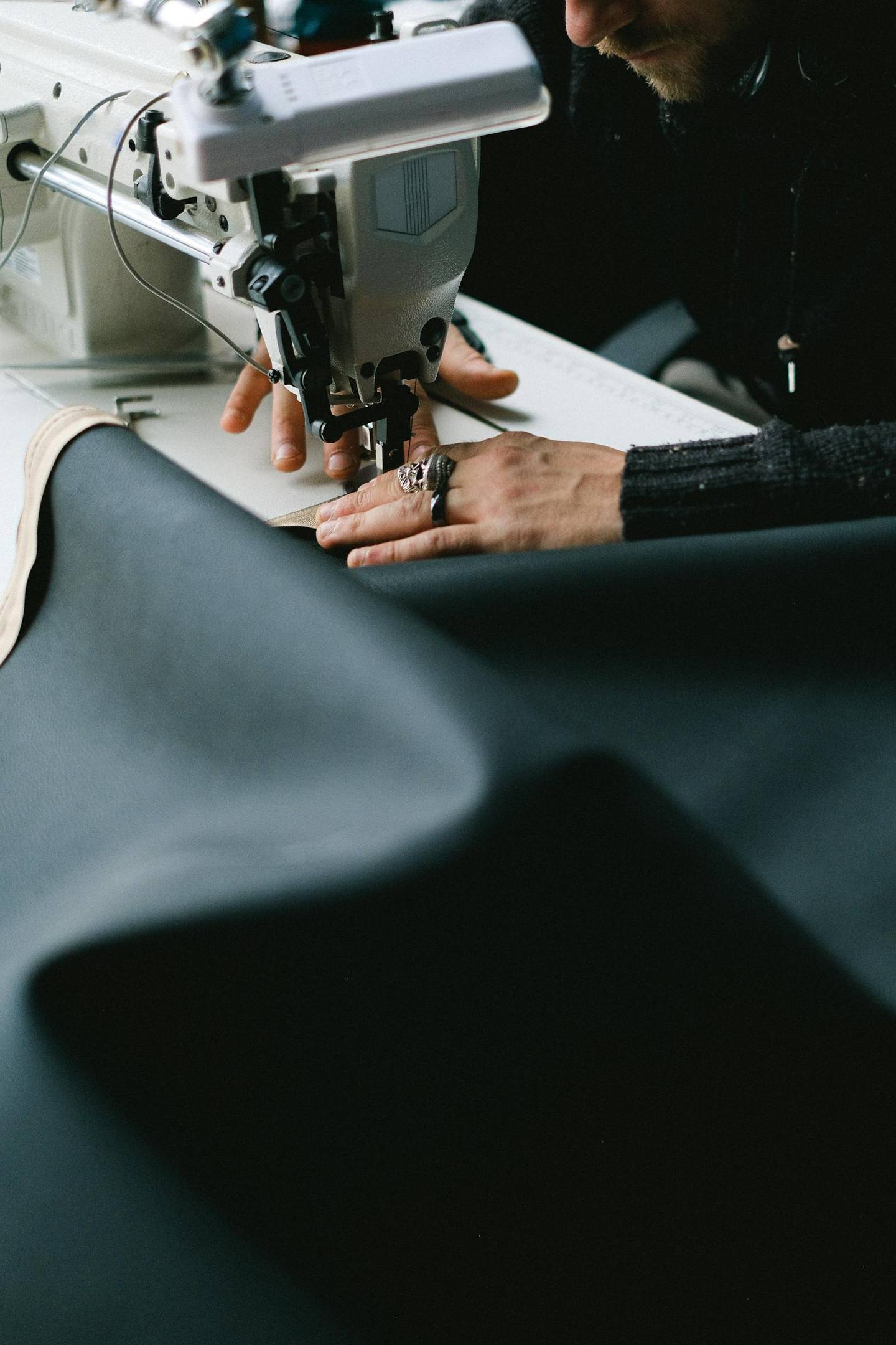 Hands guiding fabric through a sewing machine during product development.