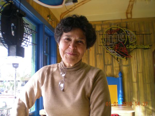 Rosa Tunberg smiles at the camera. She has short curly hair and is wearing a beige turtleneck.