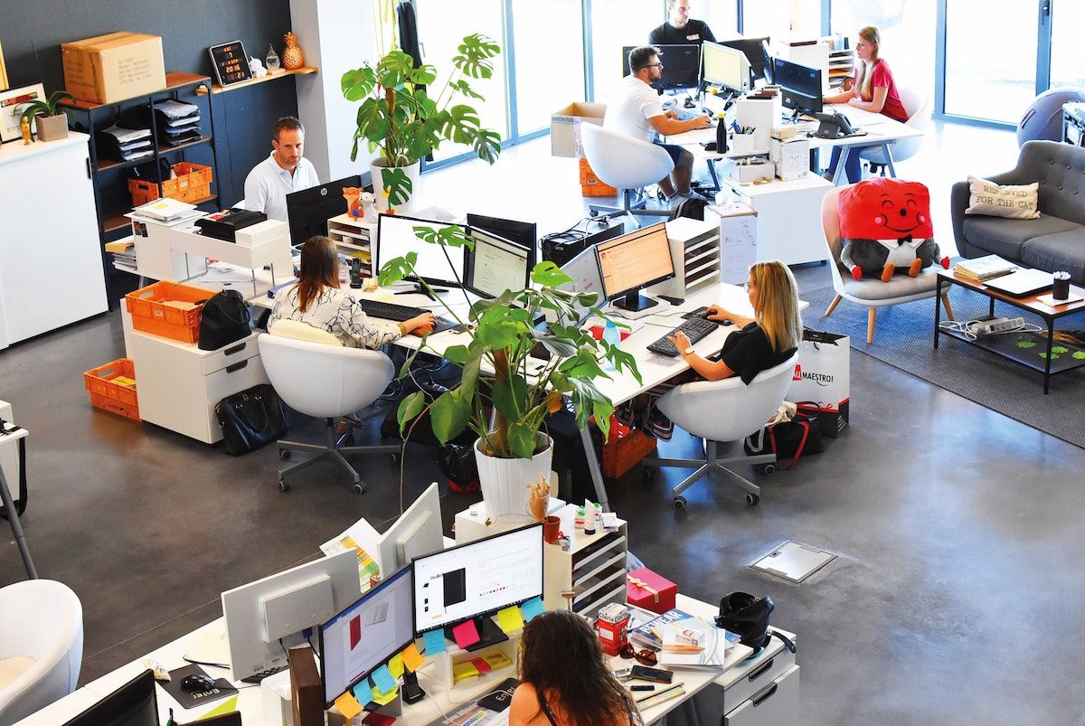 Aerial view of open modern office with people working at desks 