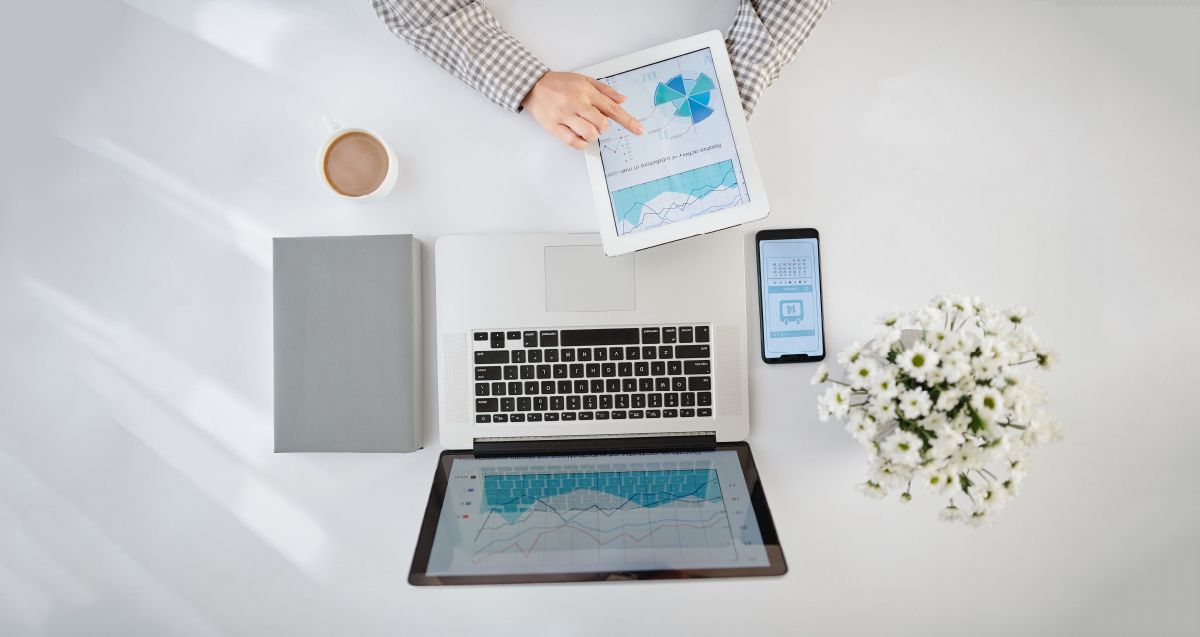 Aerial view of desk with laptop, ipad, iphone and notebook
