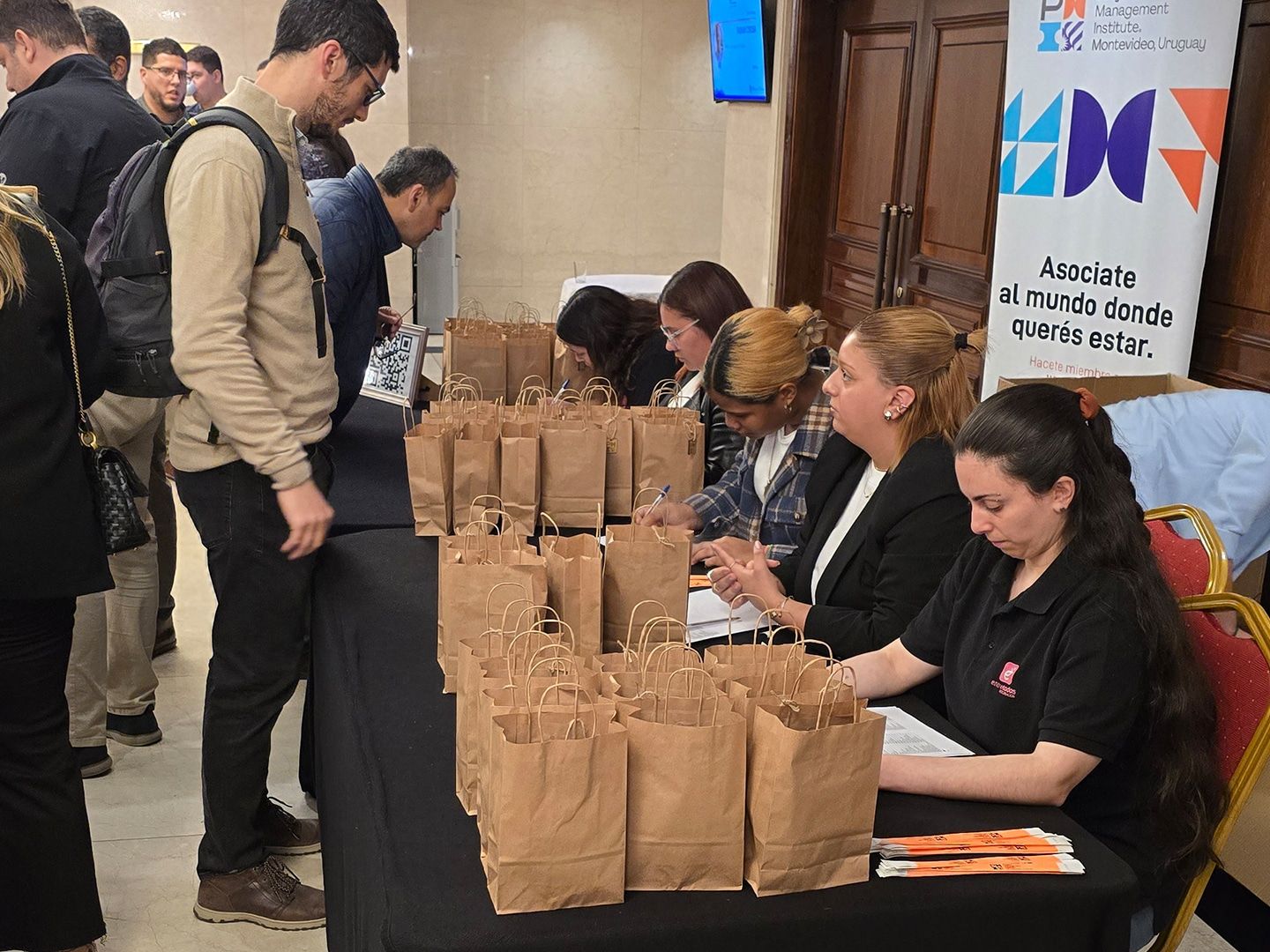 Acreditaciones: los asistentes retiran bolsas con materiales en una mesa de recepción