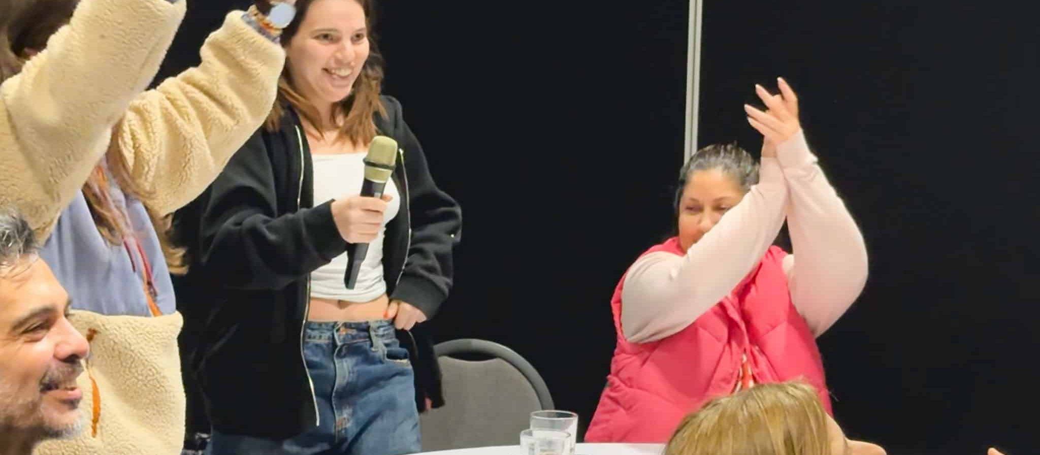 Participantes de una actividad de Entre Todos cantando y aplaudiendo