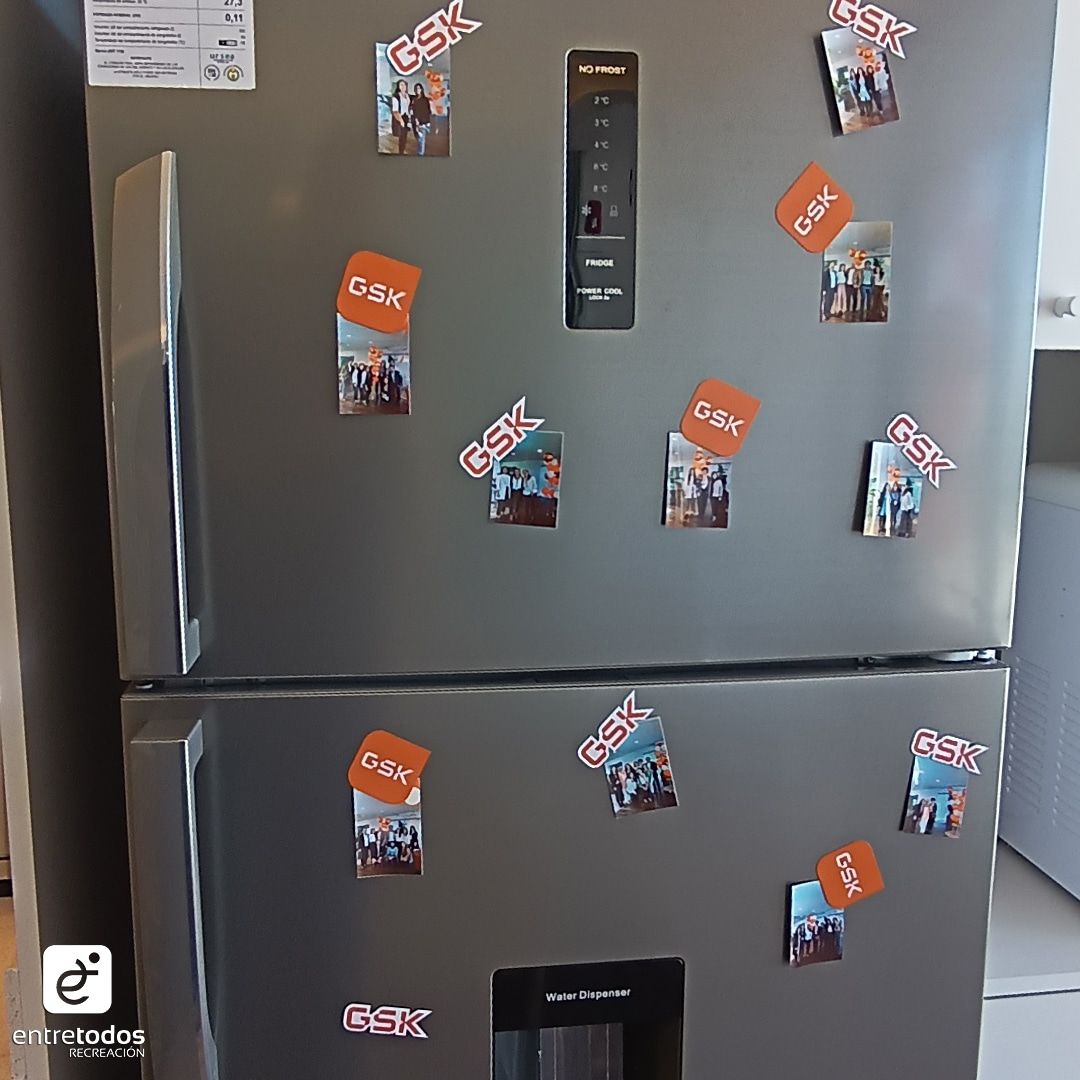 Una heladera de la oficina nueva decorada con imanes de fotos con el logo de GSK