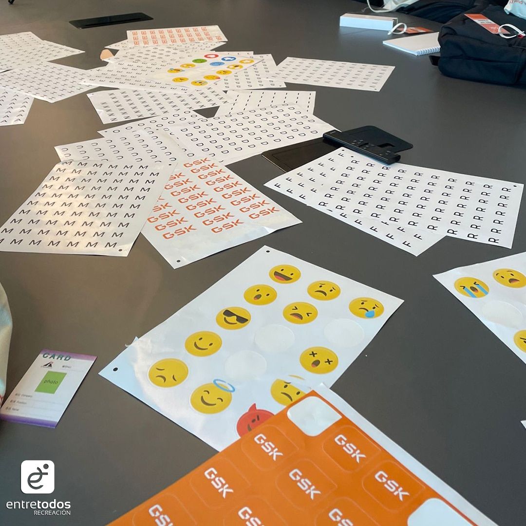 Planchas de stickers de emojis y de letras sobre una mesa, listas para la actividad