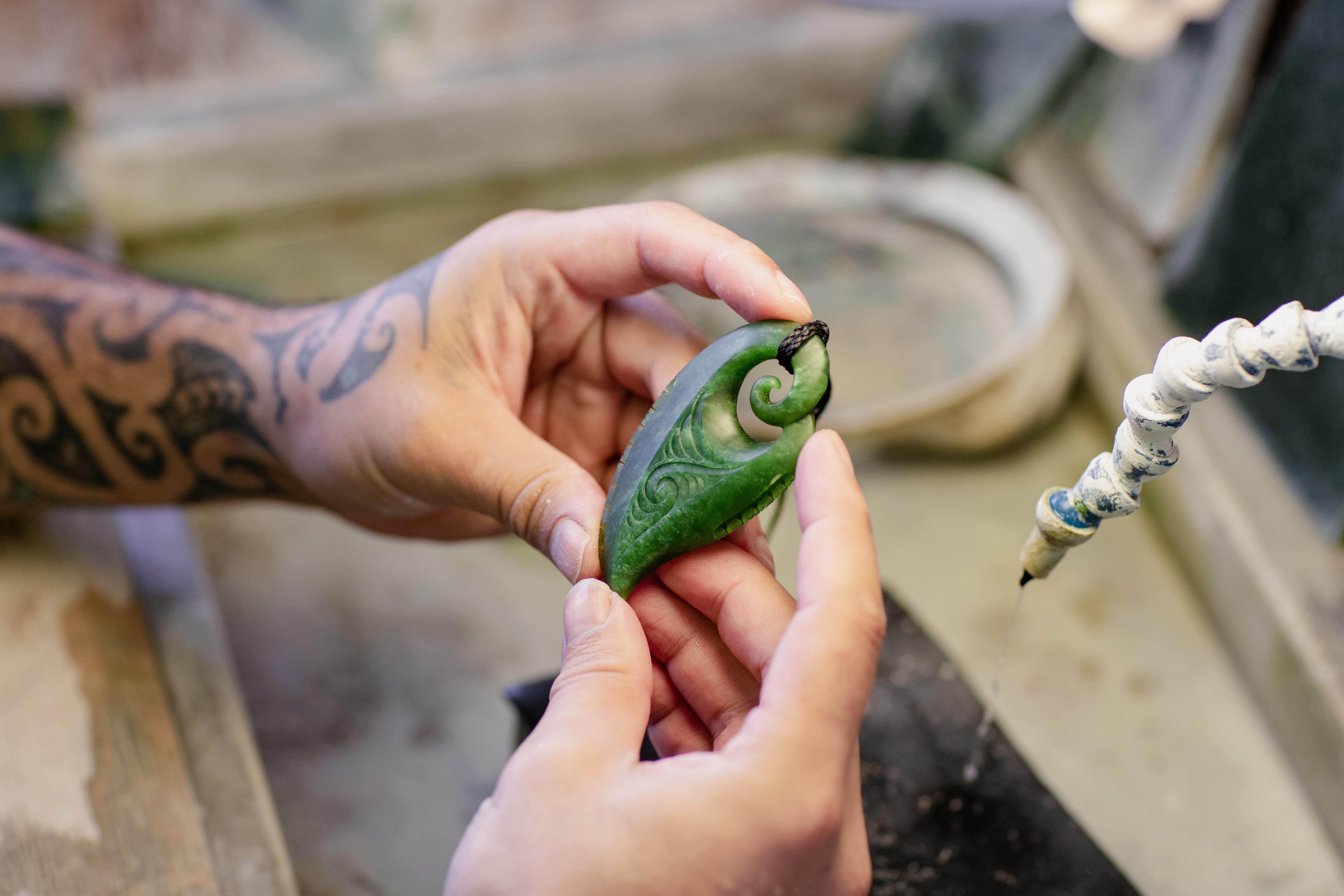 Man holding pounamu niho tooth