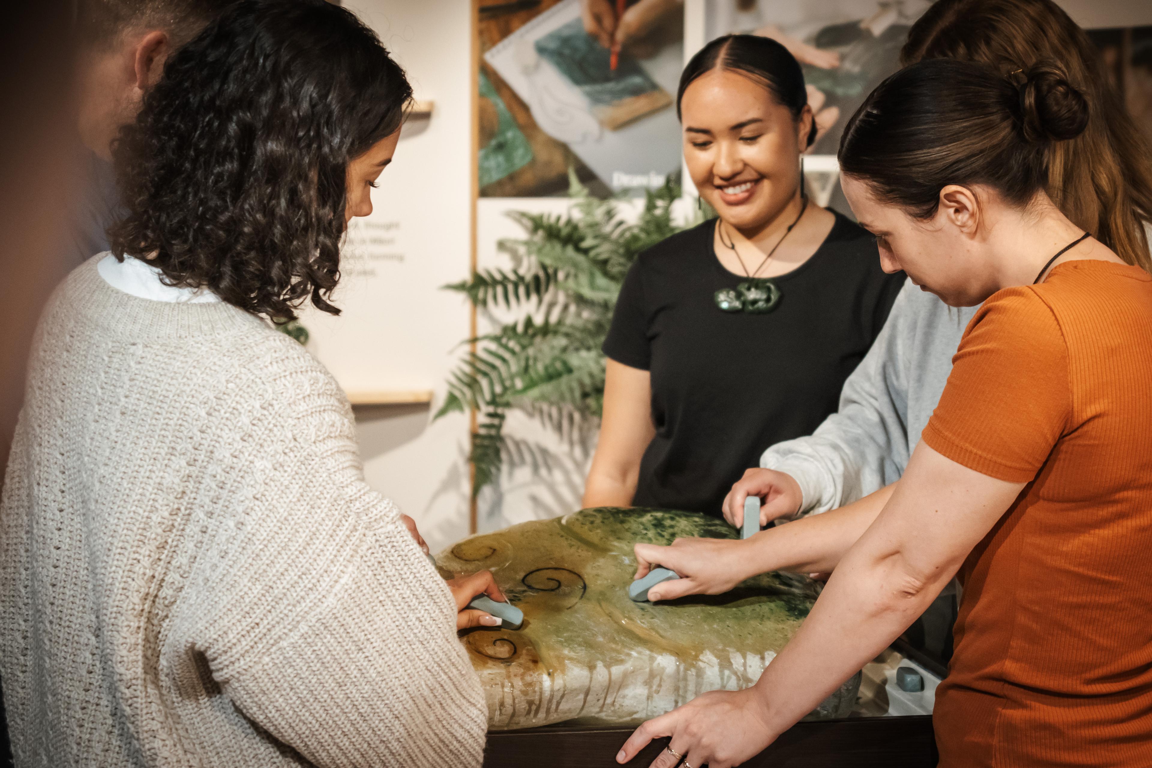 Visitors trying traditional hand carving