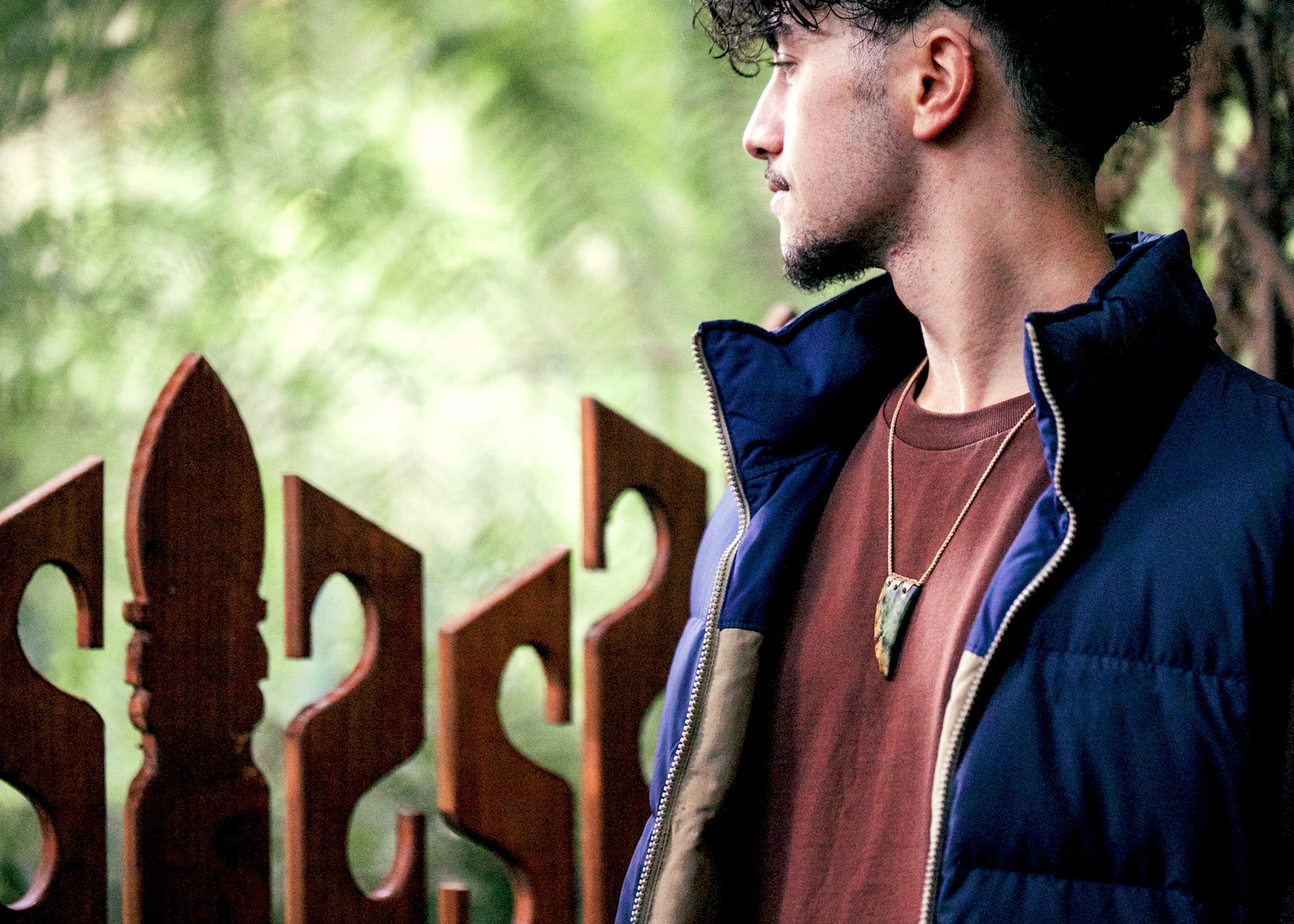 Man in forest wearing pounamu tooth