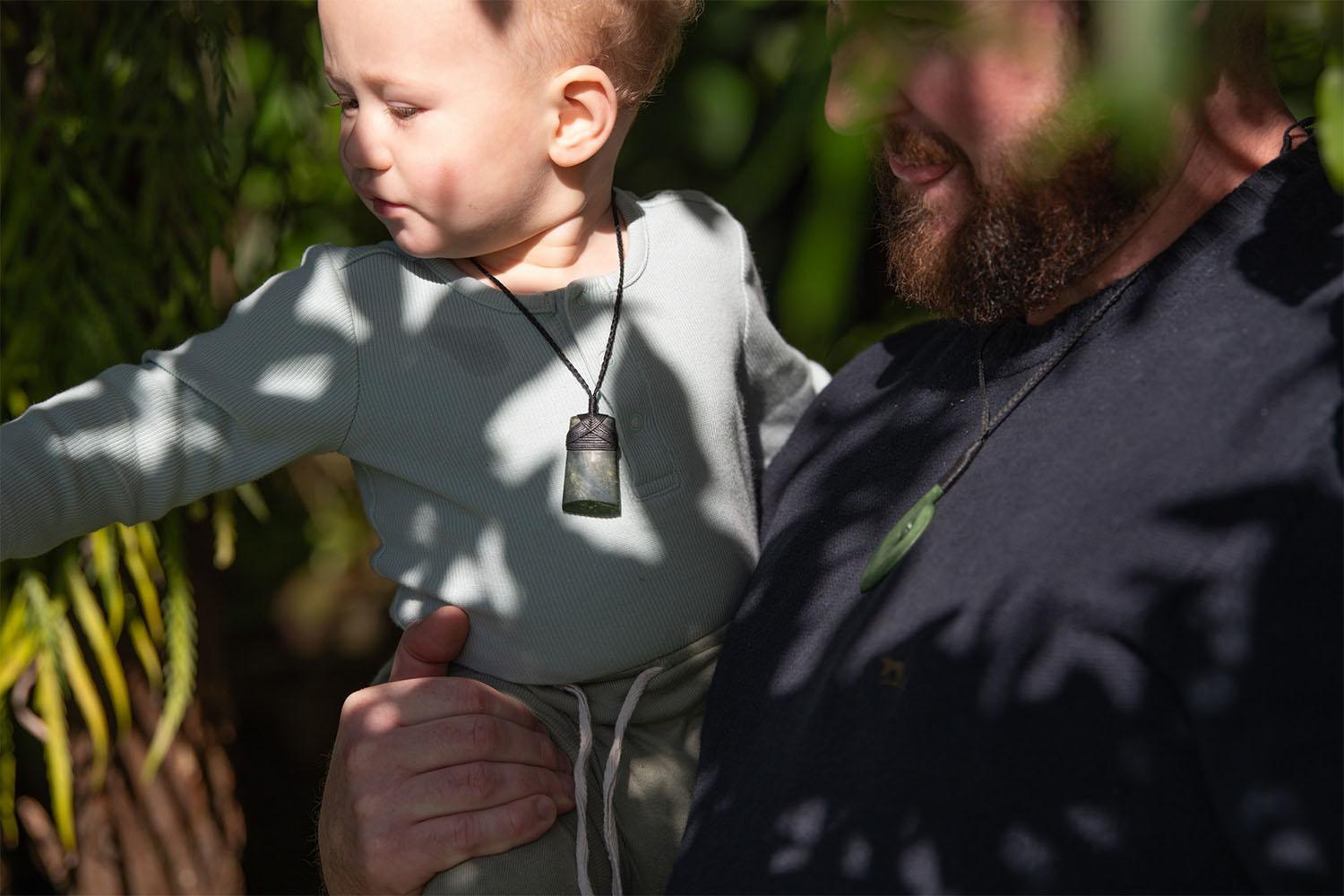 Father and son wearing toki necklace