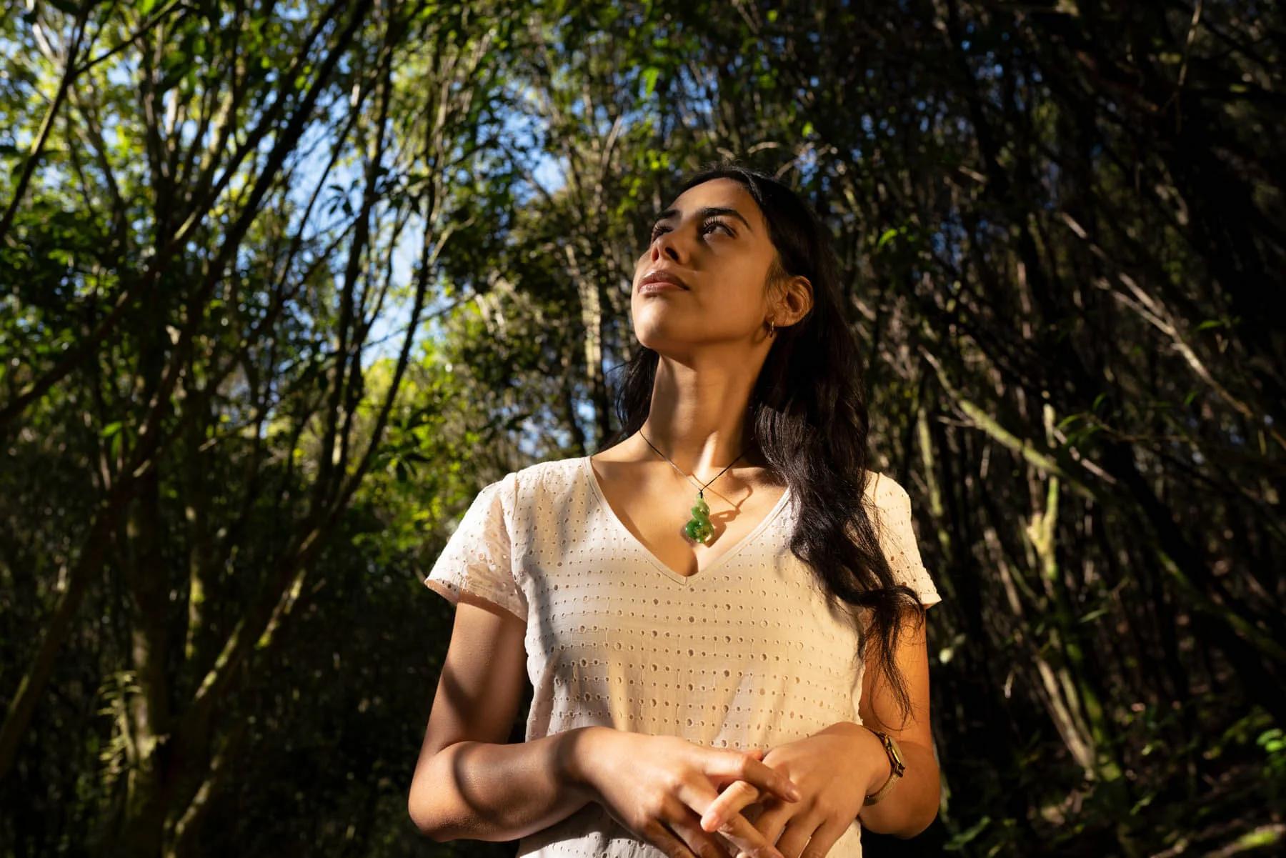 Woman wearing Pikorua necklace in the forest