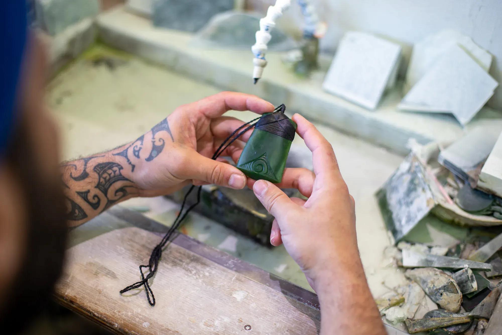 Man inspecting pounamu