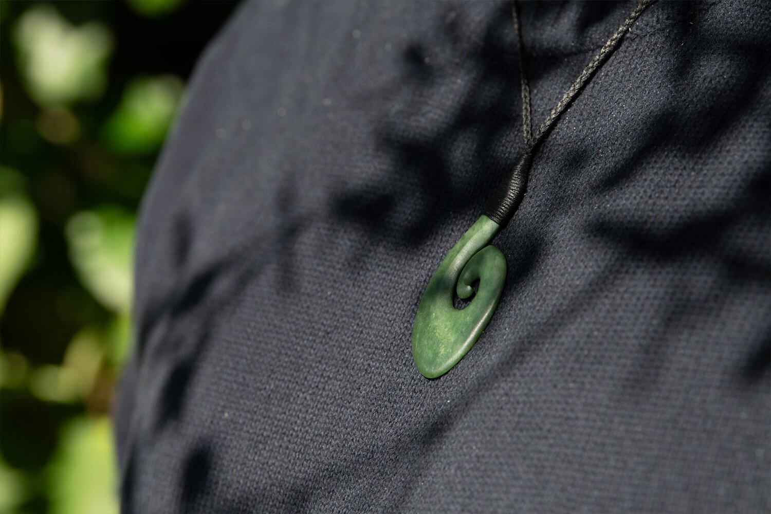 Model wears pounamu Hei Matau 