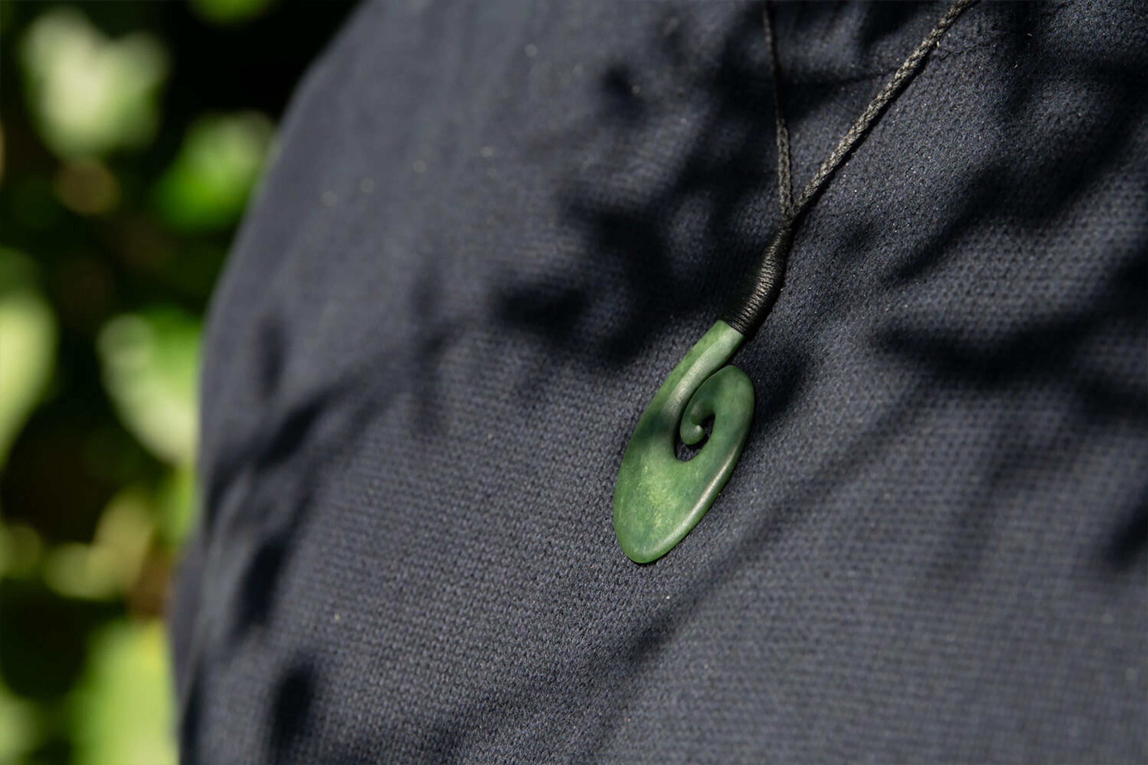Model wears pounamu Hei Matau