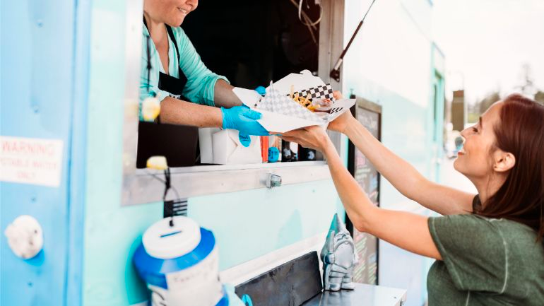 A women receiving her order at a food truck