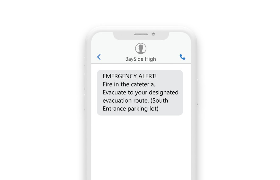 a phone showing the emergency sms: “Emergency Alert: Fire in the Cafeteria. Evacuate to your designated evacuation routes. (South Entrance Parking Lot)”