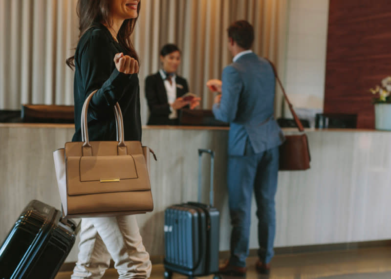 a hotel lobby with guests checking in with their suitcases