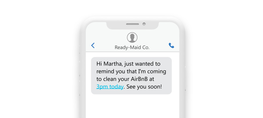 a phone showing a text reading: “Hi Martha, Just wanted to remind you that I am coming in to clean your AirBnb at 3pm today. See you soon!”