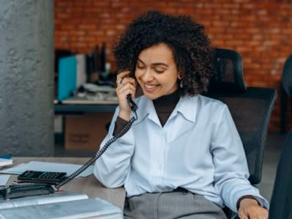  A woman talking on a landline phone